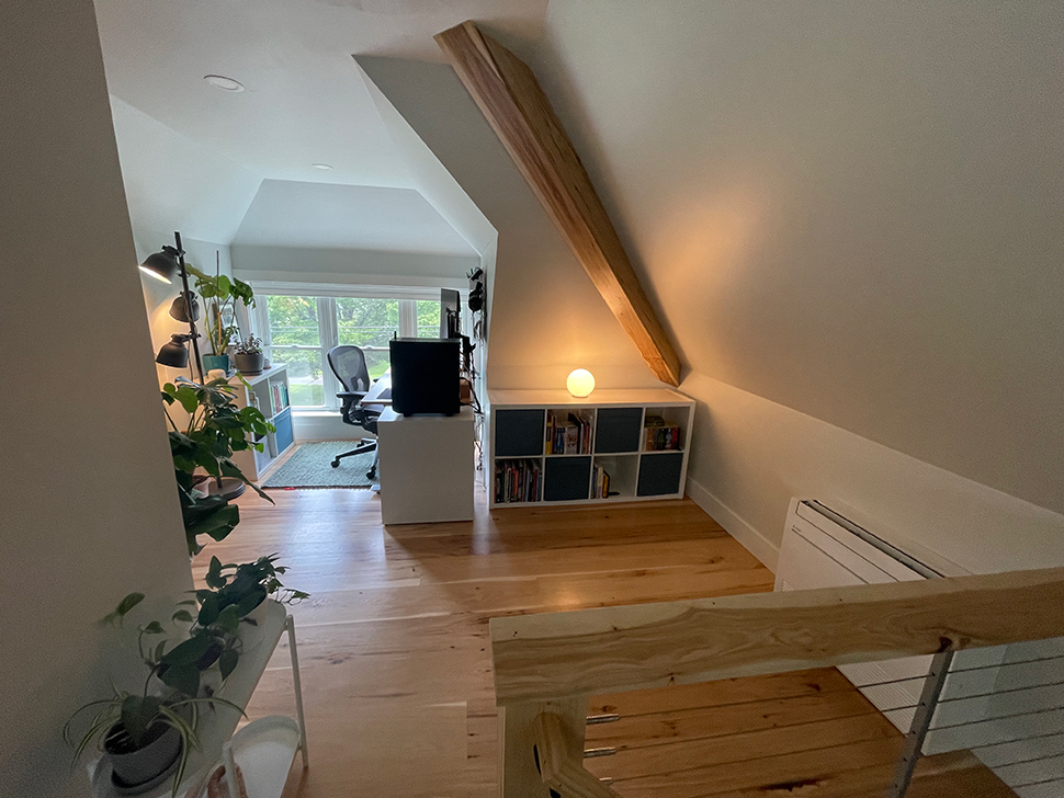 Another wide angle shot of the same dormer view. You can see the mini split, one of the storage shelves, plants, and the dormer office setup.