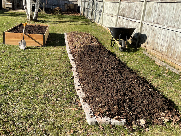 Adding a layer of finished compost.